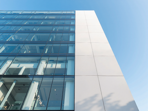 Modern office building exterior with glass facade, blue sky background, professional corporate image